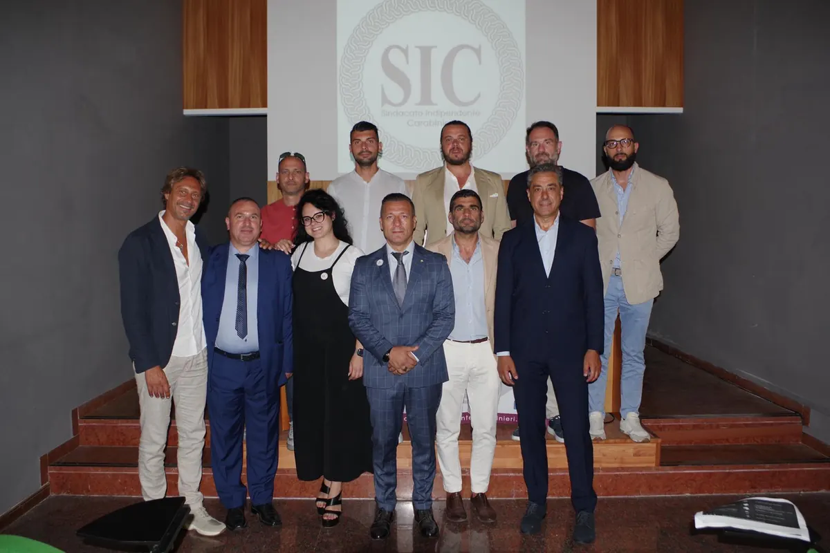 Dirigenti e iscritti SIC sorridenti sul palco al termine di un’assemblea in Abruzzo